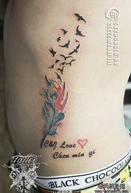 motivo tatuaggio rondine piumato colore vita laterale