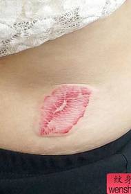 la vita di una ragazza con un motivo a tatuaggio colorato con labbra stampate