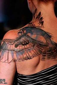 θηλυκό πίσω ένα πετώντας μεγάλο σχέδιο τατουάζ πουλιών