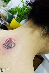 Татуировка с маленькой короной на спине