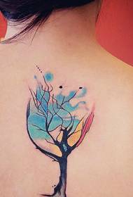 少女の背中に創造的な色の小さな木のトーテムタトゥー