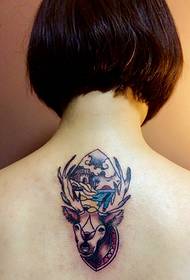 女の子は背中に独特のトーテムのタトゥーの絵があります