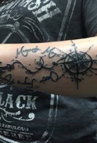 Tattoo arm გოგონა გოგონას მკლავზე ინგლისურზე და კომპასის ტატულის სურათზე