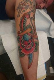 Rose dagger tattoo picture of a rose dagger tattoo on a boy's arm