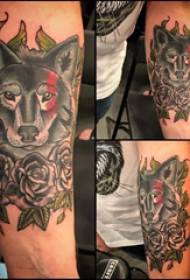 Braccio da scolaretto con lupo e motivo floreale sull'immagine del tatuaggio lupo e fiore