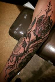 Plant tatoeëring, manlike arm, eng piranha tatoeëer prentjie