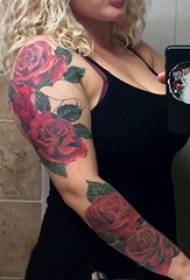 Braccio della ragazza del tatuaggio del fiore sull'immagine colorata del tatuaggio del braccio rosa