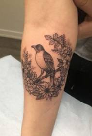 Tatuaje de brazo material de rapaza de flores e tatuaxe de aves no brazo