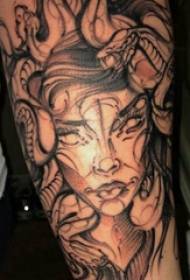 U bracciu di una ragazza di u tatuu di Medusa nantu à una foto di tatuosa di Medusa grigia negra