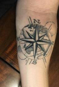 Braccio dello studente maschio della bussola del tatuaggio sull'immagine grigia nera della bussola del tatuaggio
