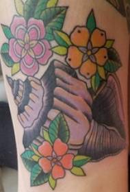 Tatuiruotės mergaitės rankos statymas ant tatuiruotės ir gėlių tatuiruotės paveikslo