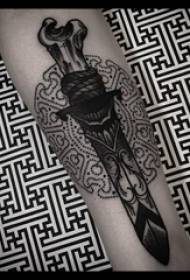 Braccio materiale del tatuaggio braccio del ragazzo sull'immagine del tatuaggio pugnale nero