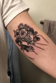 Gėlių tatuiruotės berniuko personažas ant rankos ir gėlių tatuiruotės paveikslėlis