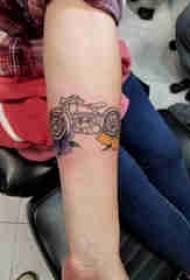 Дјевојка за руку с тетоважом за мотоцикле на слици за цвијеће и мотоцикл