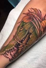 ベール動物の入れ墨の葉とワニのタトゥーの写真の男性の腕