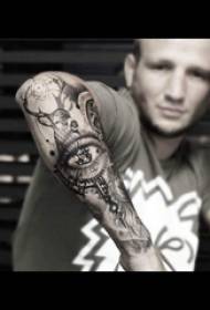 Tatuatge d'ulls, esbós, tatuatge, imatge del tatuatge dels ulls al braç del noi