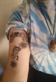 Tattoo simbool meisie se arm op blom en vraagteken tatoeëer prentjie