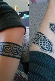 Bracciu di tatuu di materiale bracciale masciu nantu à una stampa di tatuaggi di bracciu neru
