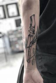 Tatuiruotės juoda vyriškos lyties studento ranka ant augalų ir durklų tatuiruotės paveikslo