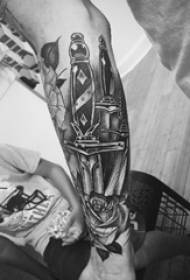 Tatuiruotės juoda vyriškos lyties studento ranka ant rožių ir durklų tatuiruotės paveikslo