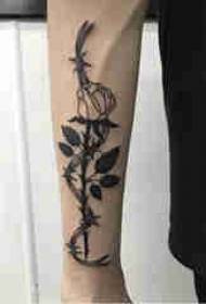 Planta brazo do neno tatuado na tatuaxe de flor negra