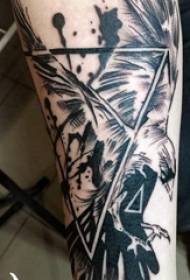 Tatui il braccio nero dello studente maschio sull'immagine del tatuaggio dell'uccello e del triangolo