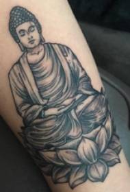Tetovált kép egy tetovált alak egy tetoválás egy fekete és szürke Buddha a lány karját