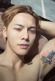 Čínska tetovacia hviezda Ken Weijun je kreatívny anglický tetovací obrázok na ramene