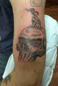 fotos de tatuagem de caveira, braço de menino, vela e tatuagem de caveira