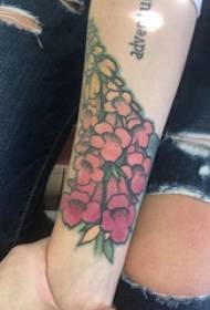 Brațul fetei cu tatuaj floral pe o imagine de tatuaj floral colorat