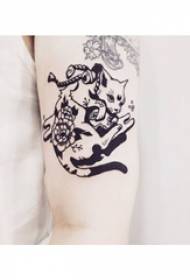 팔에 검은 고양이 문신 사진과 함께 작은 동물 문신 소녀