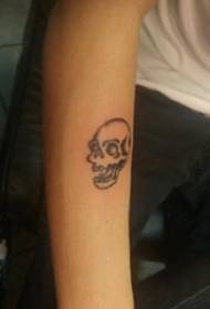 Lletra abstracta del braç del noi del tatuatge sobre un quadre de tatuatge de crani negre