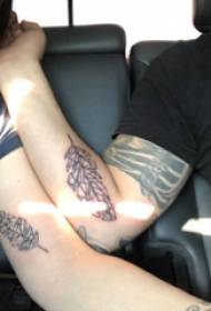 Braccio delle coppie del modello della foglia del tatuaggio sull'immagine nera del tatuaggio della foglia