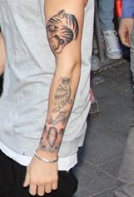 የ Justin Bieber's Tattoo Star's Arm on በጨለማ ግራጫ የእንስሳት ንቅሳት ፎቶ