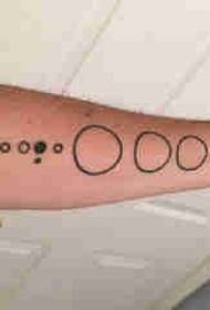 Geometriai elem tetoválás férfi hallgató karját fekete kerek tetoválás kép