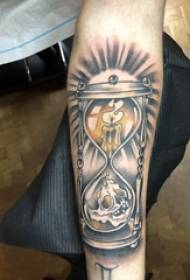 Rokas tetovējuma materiāls, zēna rokas, sveces un smilšu pulksteņa tetovējuma attēls