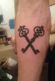 Key tattoo model boy's arm on black key tetovējuma attēls