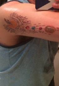 Tetovanie planéty chlapcovho ramena na farebnom obrázku planéty tetovania