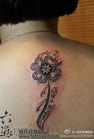 Fermoso e elegante tatuaje de trevo de catro follas na parte traseira da fermosa muller