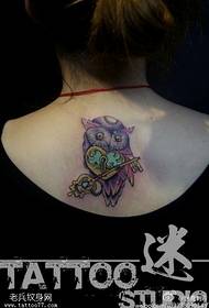Woman back colored owl key tattoo work by tattoo
