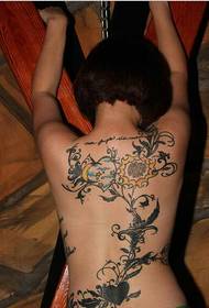 時尚女性的背部只有美麗的植物花藤紋身圖片