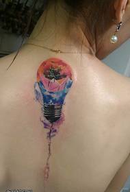 Naisen selkäväriset hehkulamppu-tatuointityöt tekevät tatuointitalosta