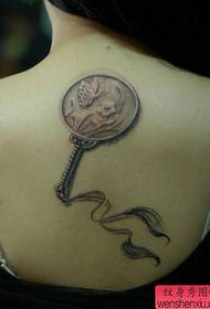 a classical small fan tattoo on the back of the girl
