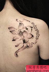 Det vackra lotusblommatatueringsmönstret på flickans baksida