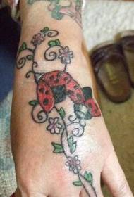Tangan berwarna dua tato ladybug tanaman yang indah
