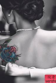 Mbrapa e bukur me model të bukur tatuazhesh me trëndafila të bukur dhe me diamant