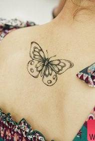 Pequeño tatuaje de mariposa fresca de espalda de mujer