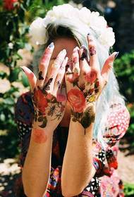 Female hand with beautiful colored rose tattoo