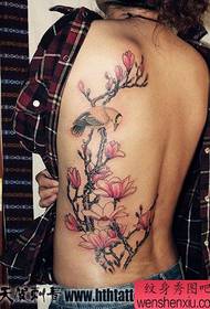 Lijepa djevojka s prekrasnim ptičjim i cvjetnim uzorkom tetovaža