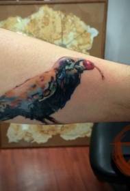 Arm med et malet tatoveringsmønster for fugl og bær